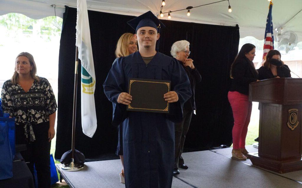 Man holding up his diploma at graduation